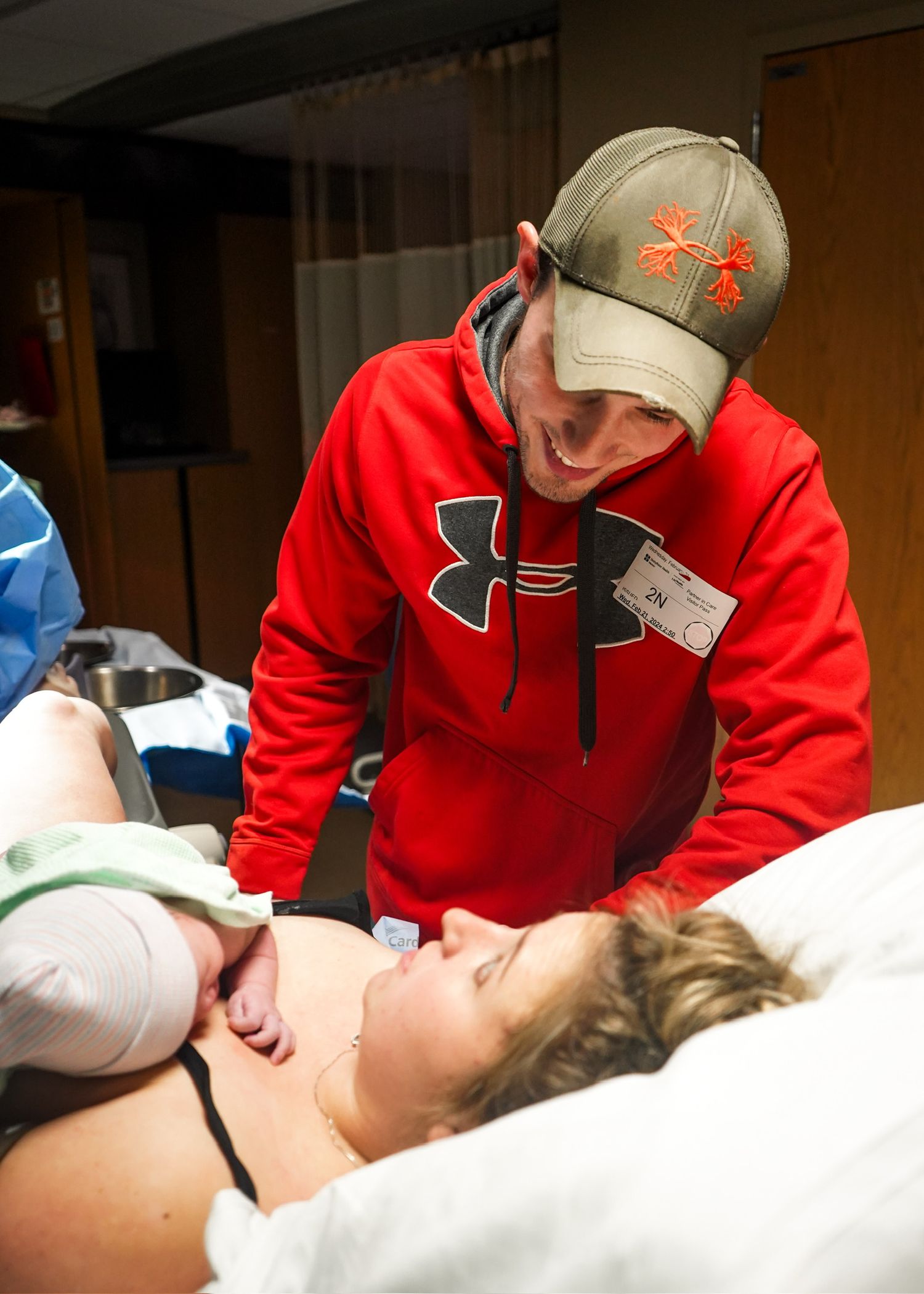 Medical team in red and blue attends to patient on hospital bed during procedure.