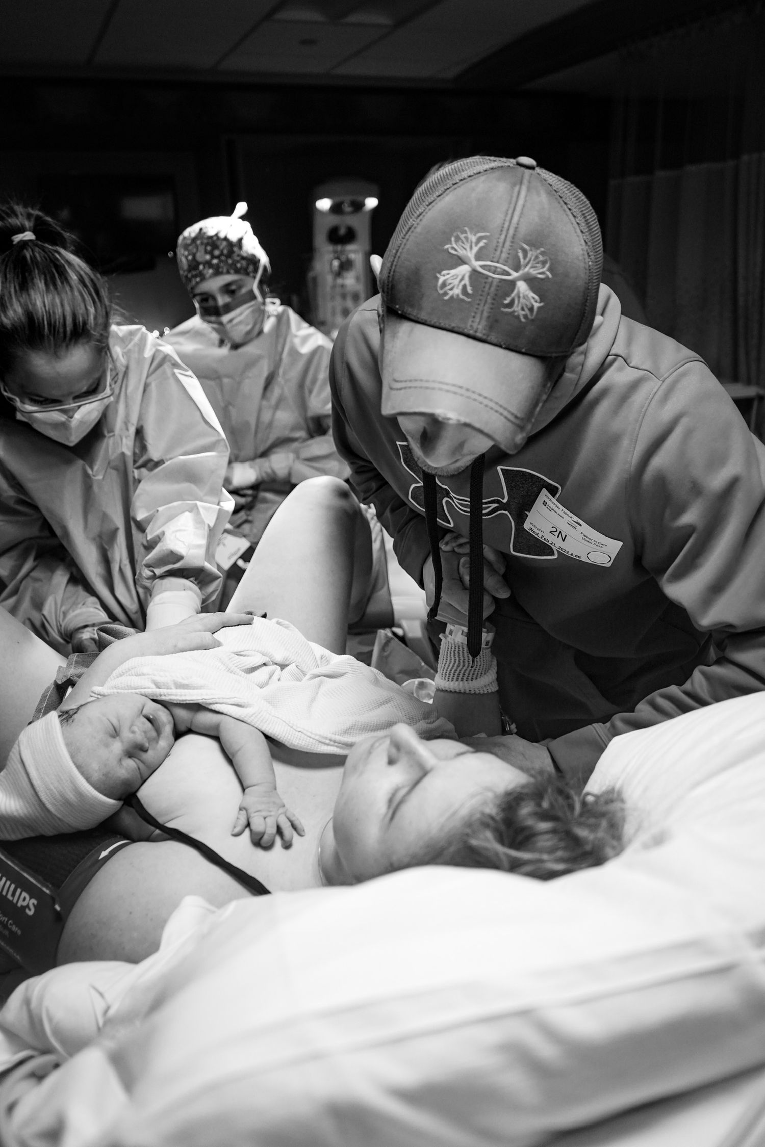 Medical staff in protective gear providing patient care during hospital procedure.