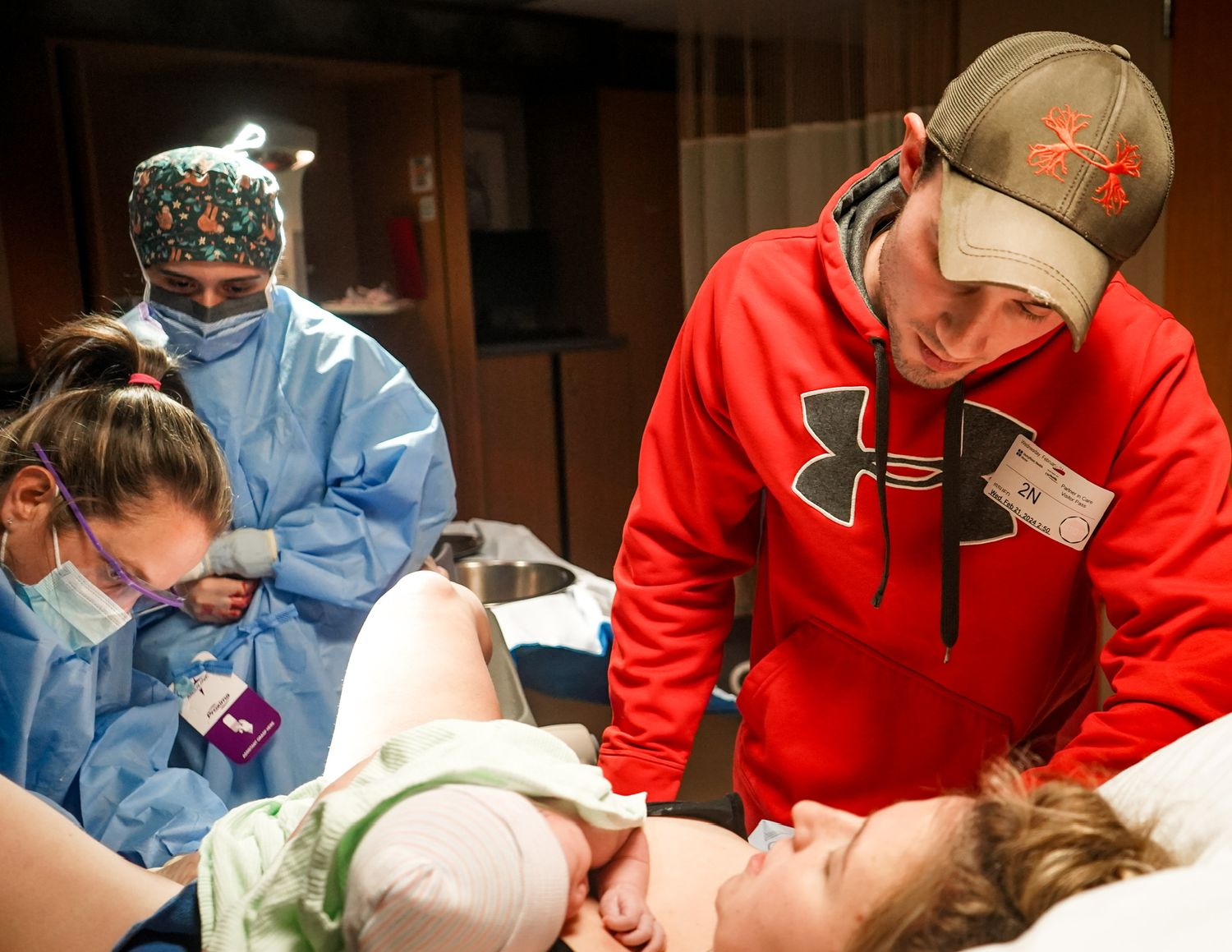 Medical procedure being performed by team wearing protective equipment in clinical setting.