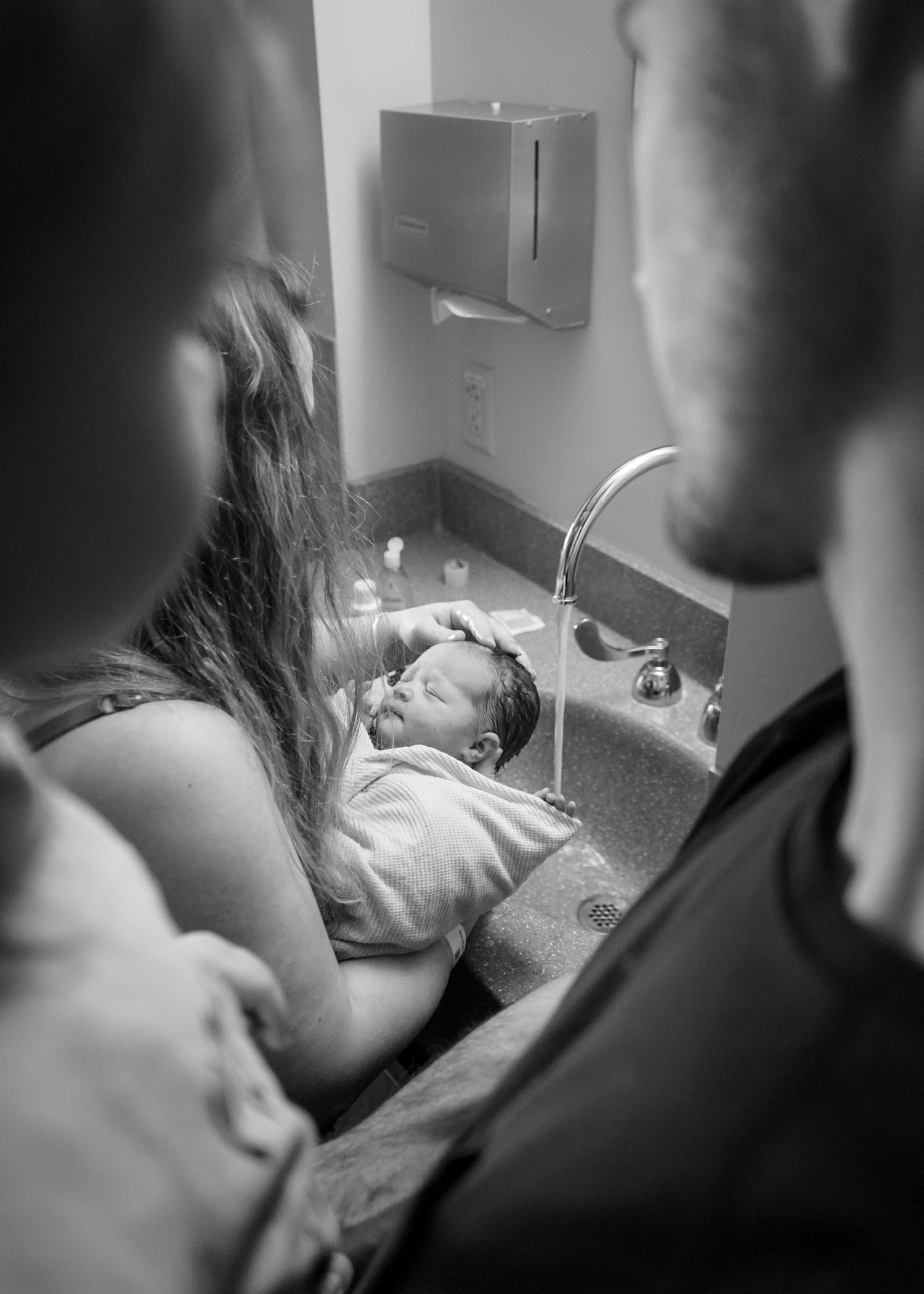 Black and white hospital scene showing medical staff attending to a newborn.