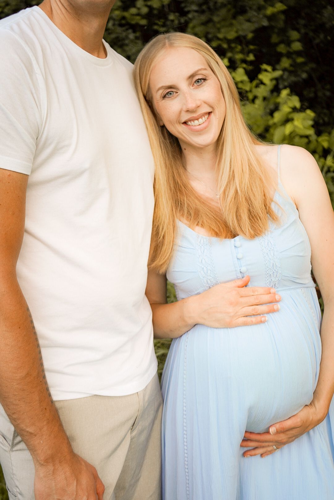 Progressive maternity photos of couple embracing outdoors with growing baby bump.