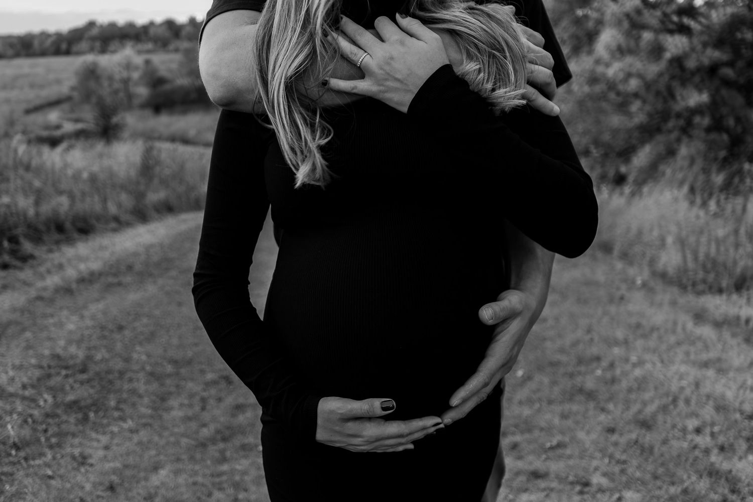 A series of black and white romantic photos showing a couple embracing and dancing in a natural outdoor setting.