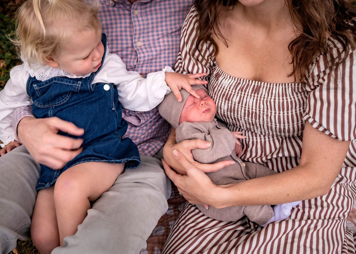 A series of tender moments showing a baby in a striped outfit being cradled and comforted.