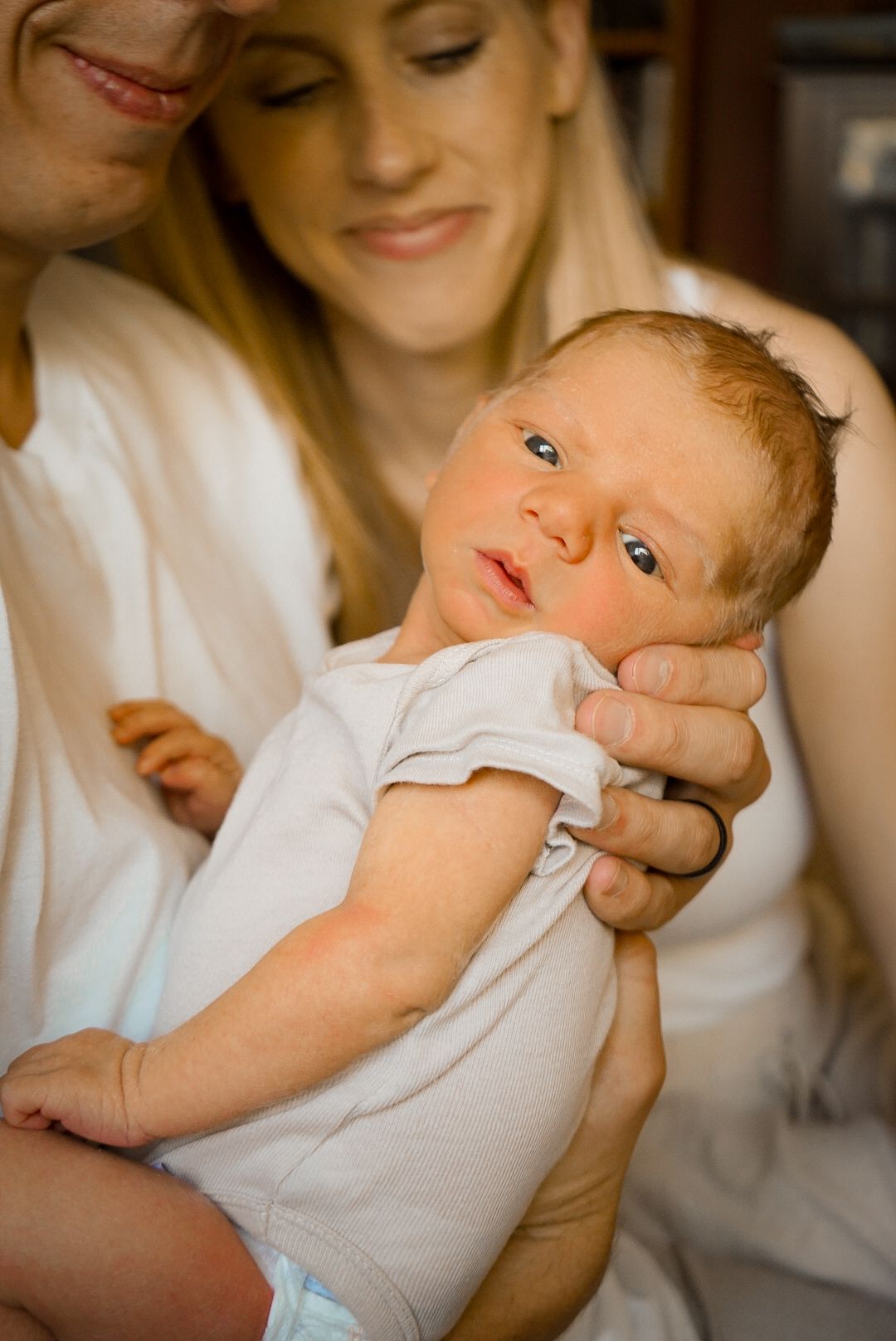 Sweet portrait series of parents bonding with their blue-eyed infant.
