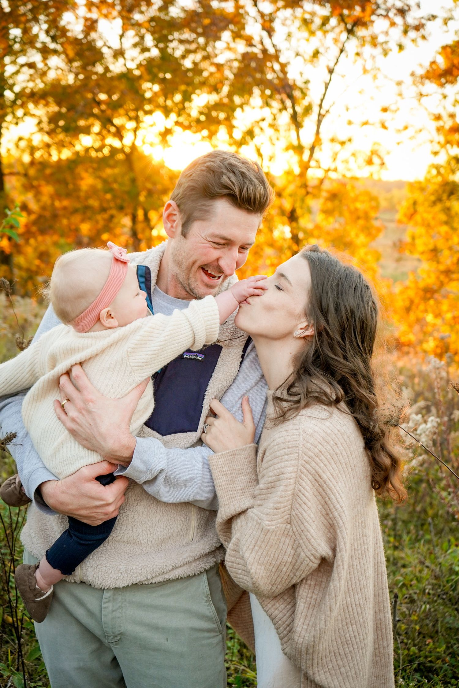 A heartwarming family moment captured in golden sunlight among autumn foliage.