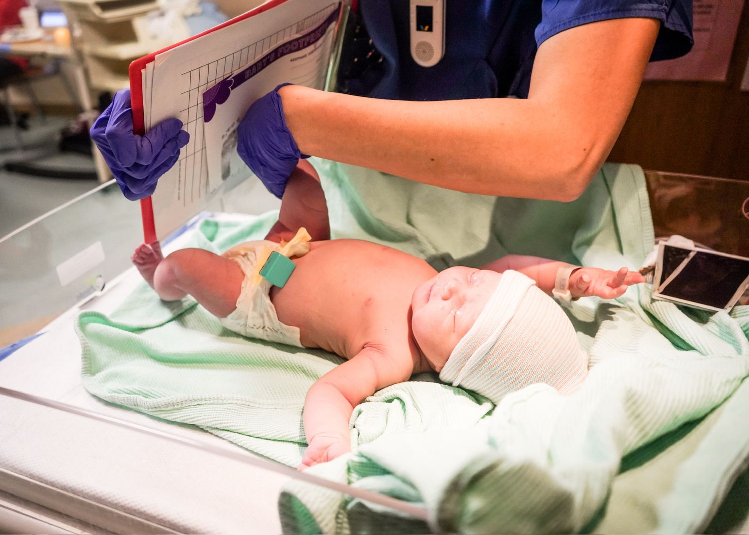 Hospital staff conducting medical examination of newborn.