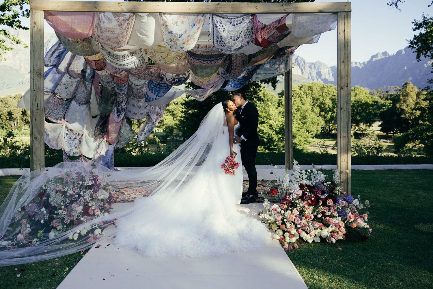 Wedding ceremony site with draped fabric and floral decorations creating a romantic outdoor setting.