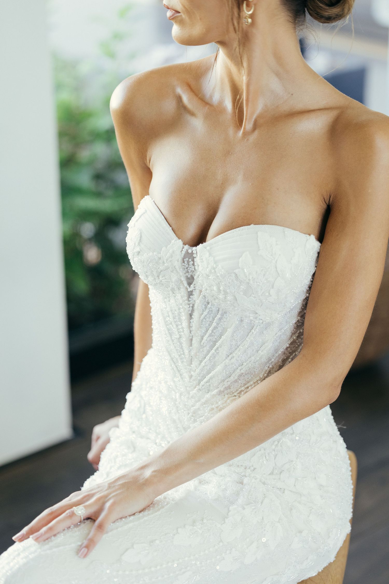 Close-up details of an intricately beaded strapless white wedding gown bodice.