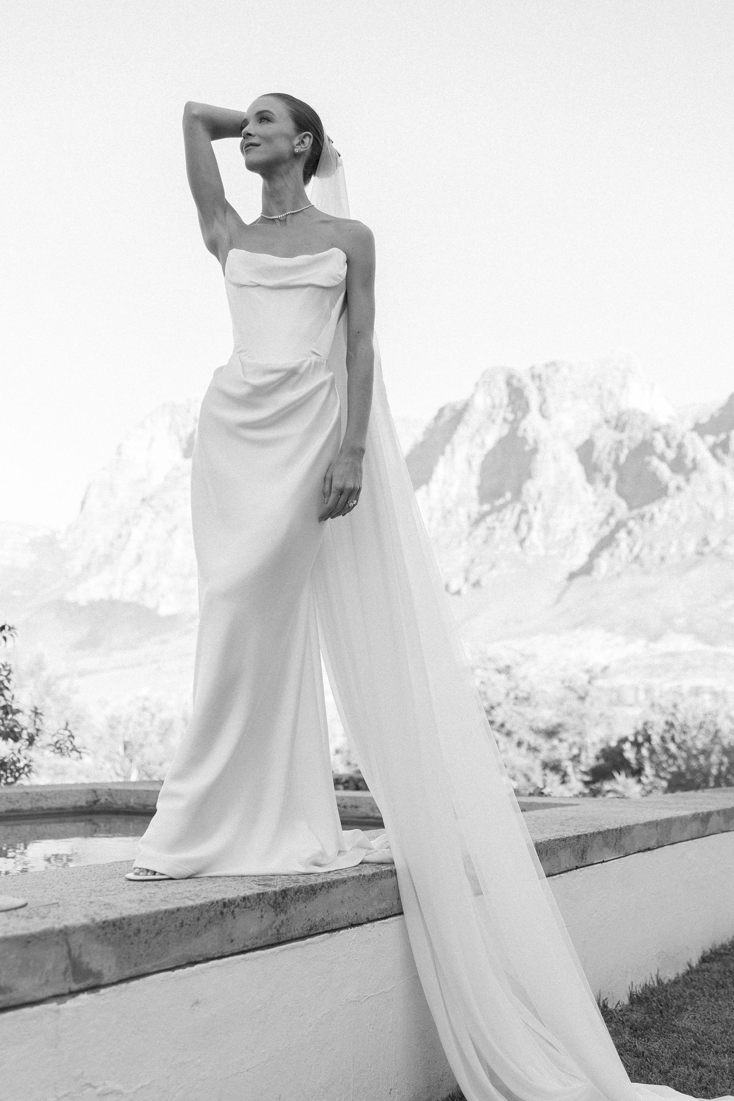 Elegant white dress flowing in the wind against a mountain backdrop.