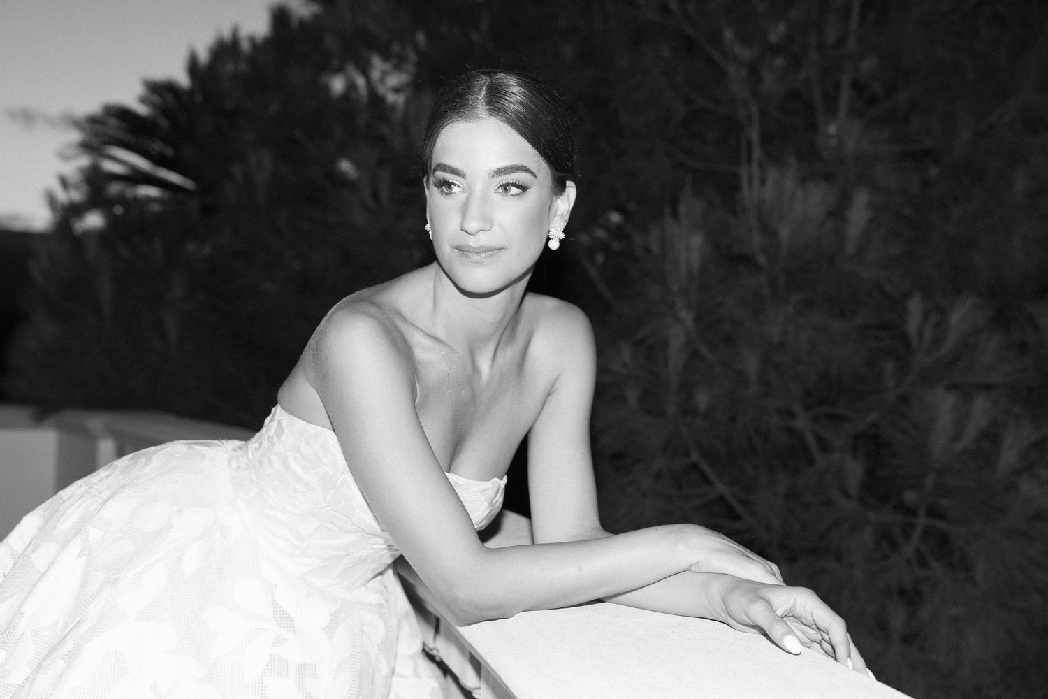 An intimate black and white portrait in an elegant wedding gown at dusk.