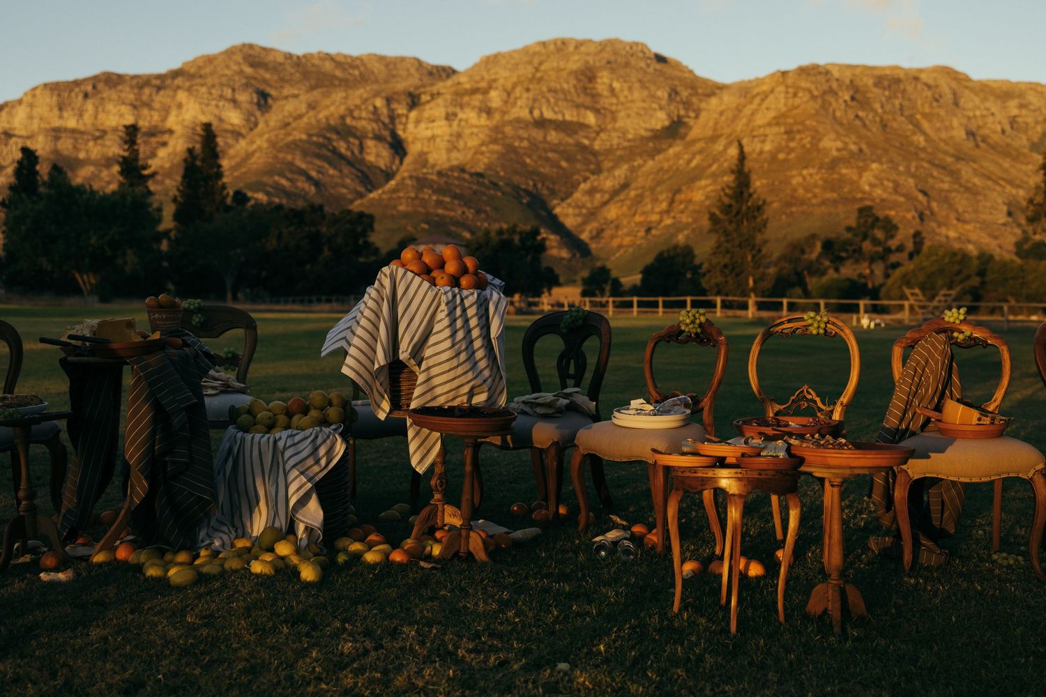 Scenic mountain landscape at sunset with outdoor event seating in the foreground.