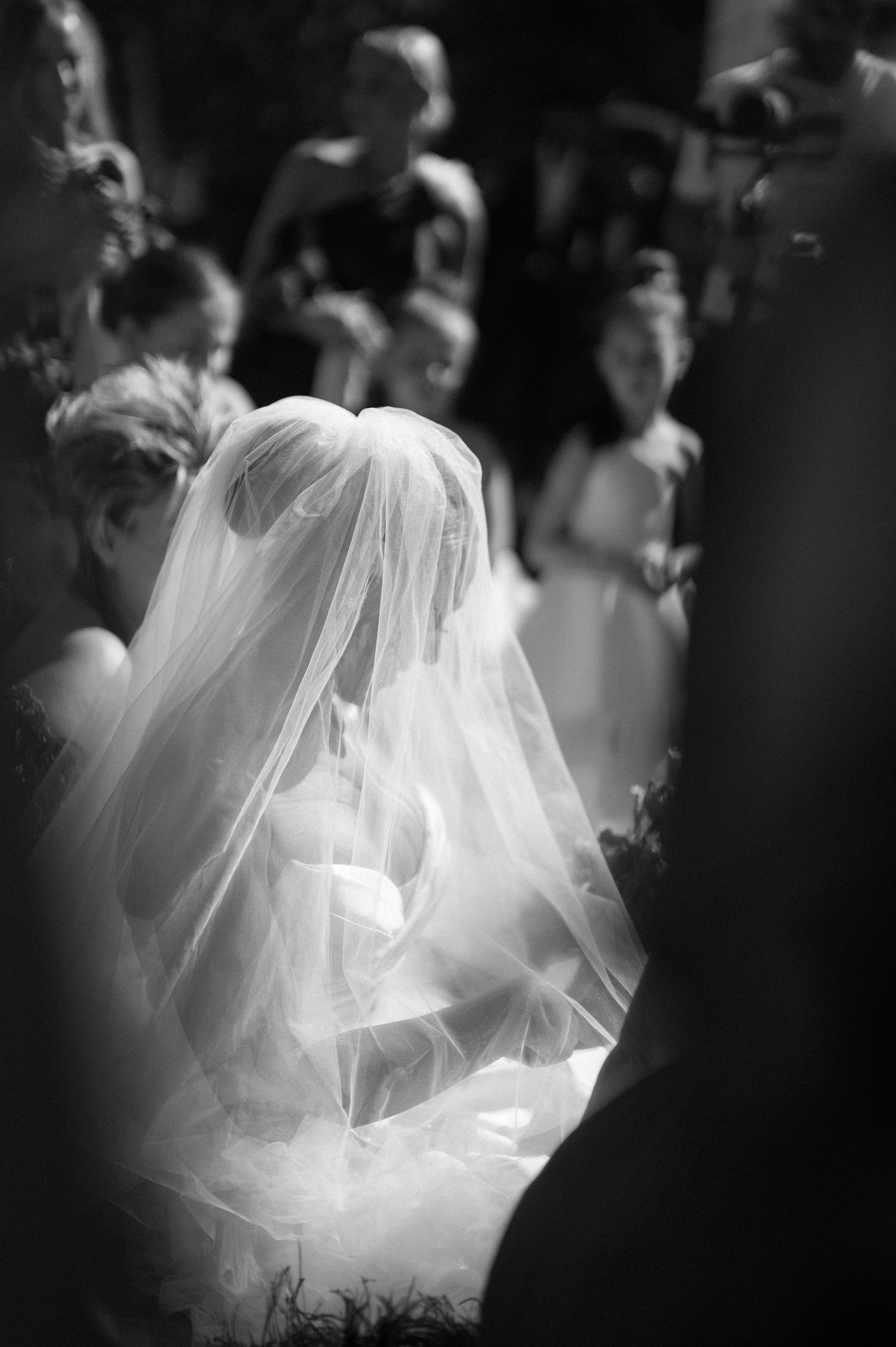 Dreamy black and white wedding photograph capturing the ethereal detail of a flowing bridal veil.