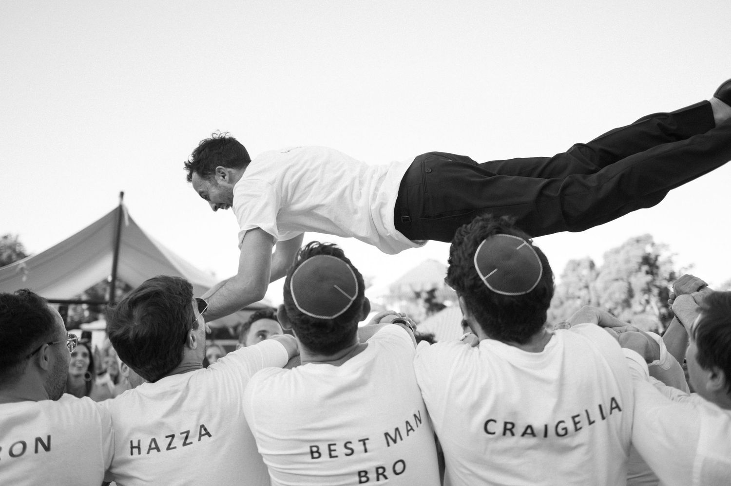 Celebratory moment at a wedding reception with guests wearing matching personalized shirts.