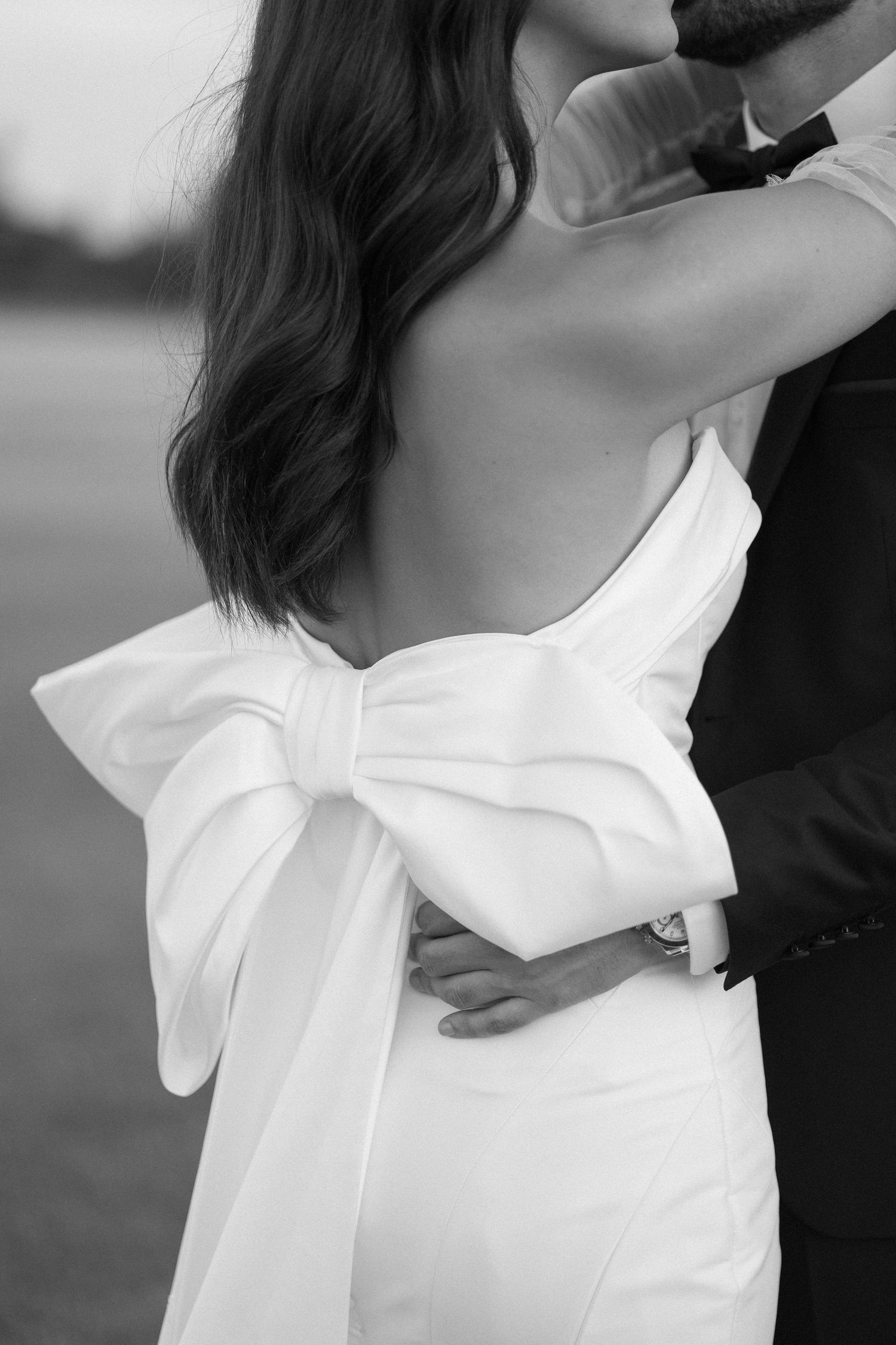 Detail shot of white wedding dress with large decorative bow on the back.