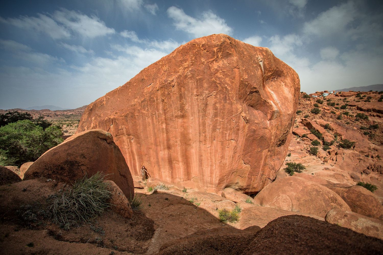 Panoramic view of red rock formations under blue skies in a desert landscape.