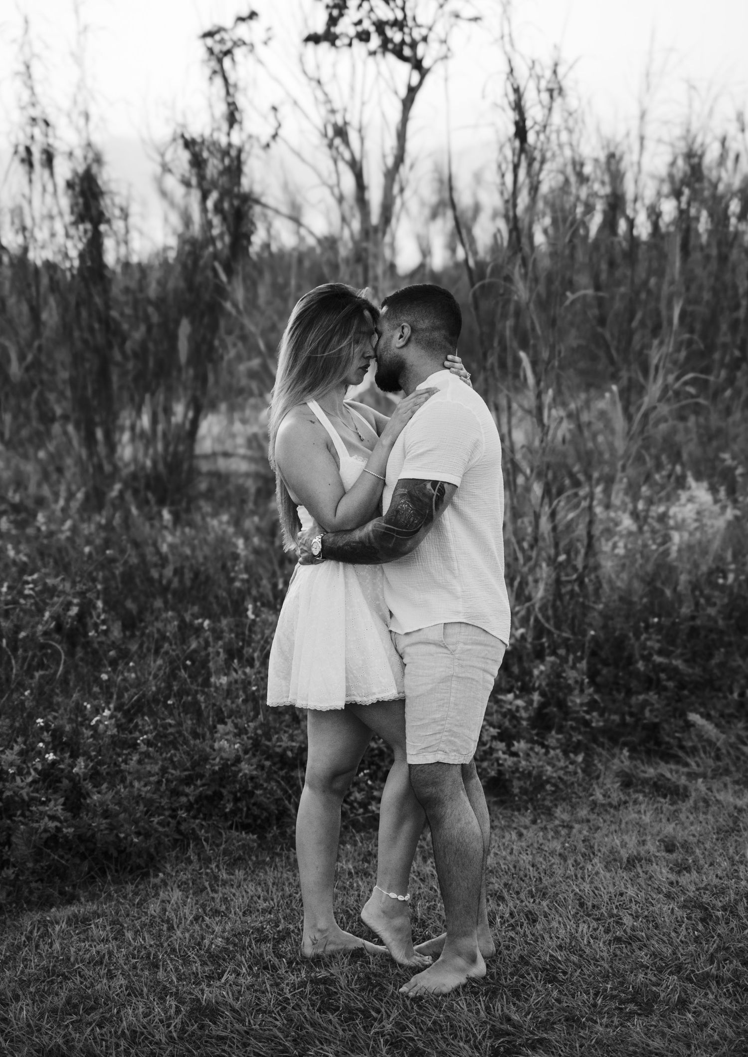 Couple gazing at each other through grassy field captured in motion