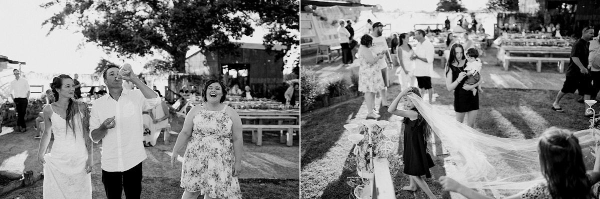 Black and white photo of wedding guests laughing and dancing outdoors at a sunny garden reception ceremony.