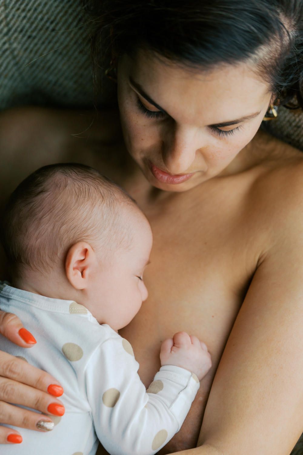 A mother tenderly breastfeeding her newborn baby, sharing a peaceful bonding moment.