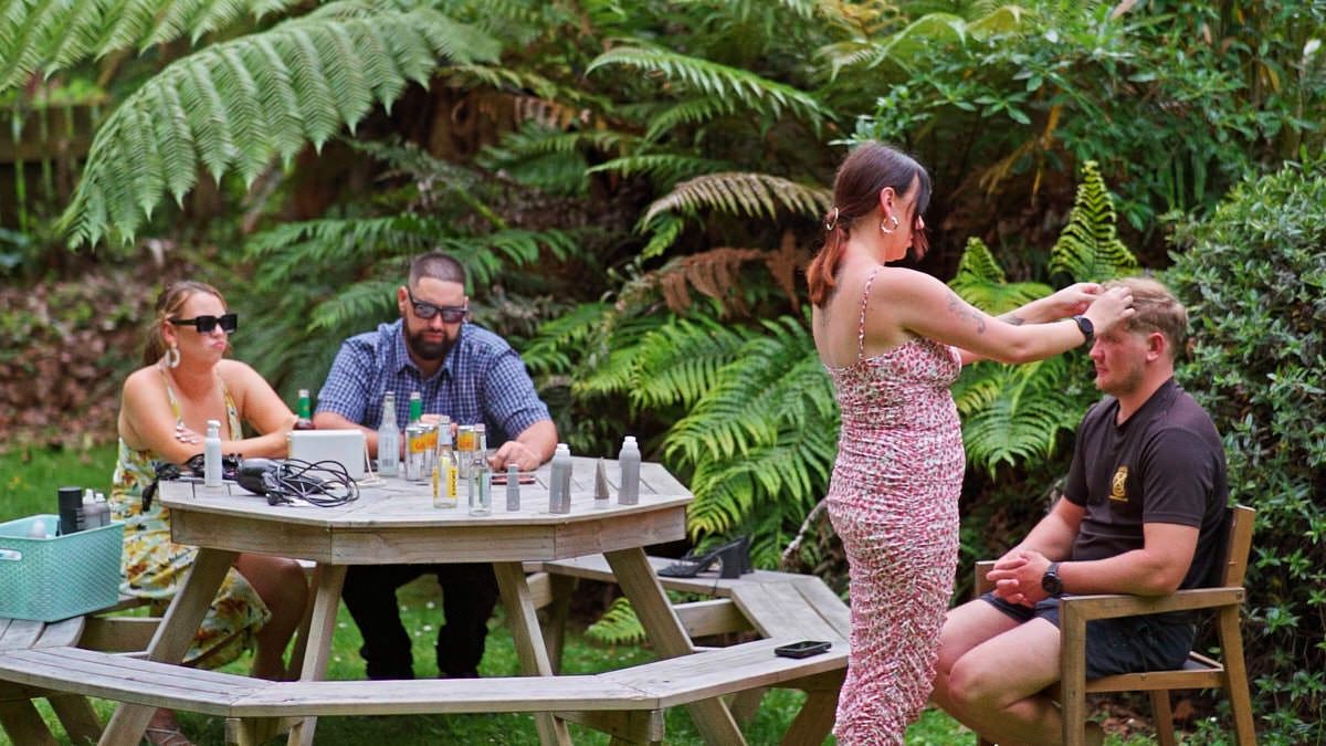 Group of four adults socializing at an outdoor picnic table surrounded by lush green ferns and tropical foliage.
