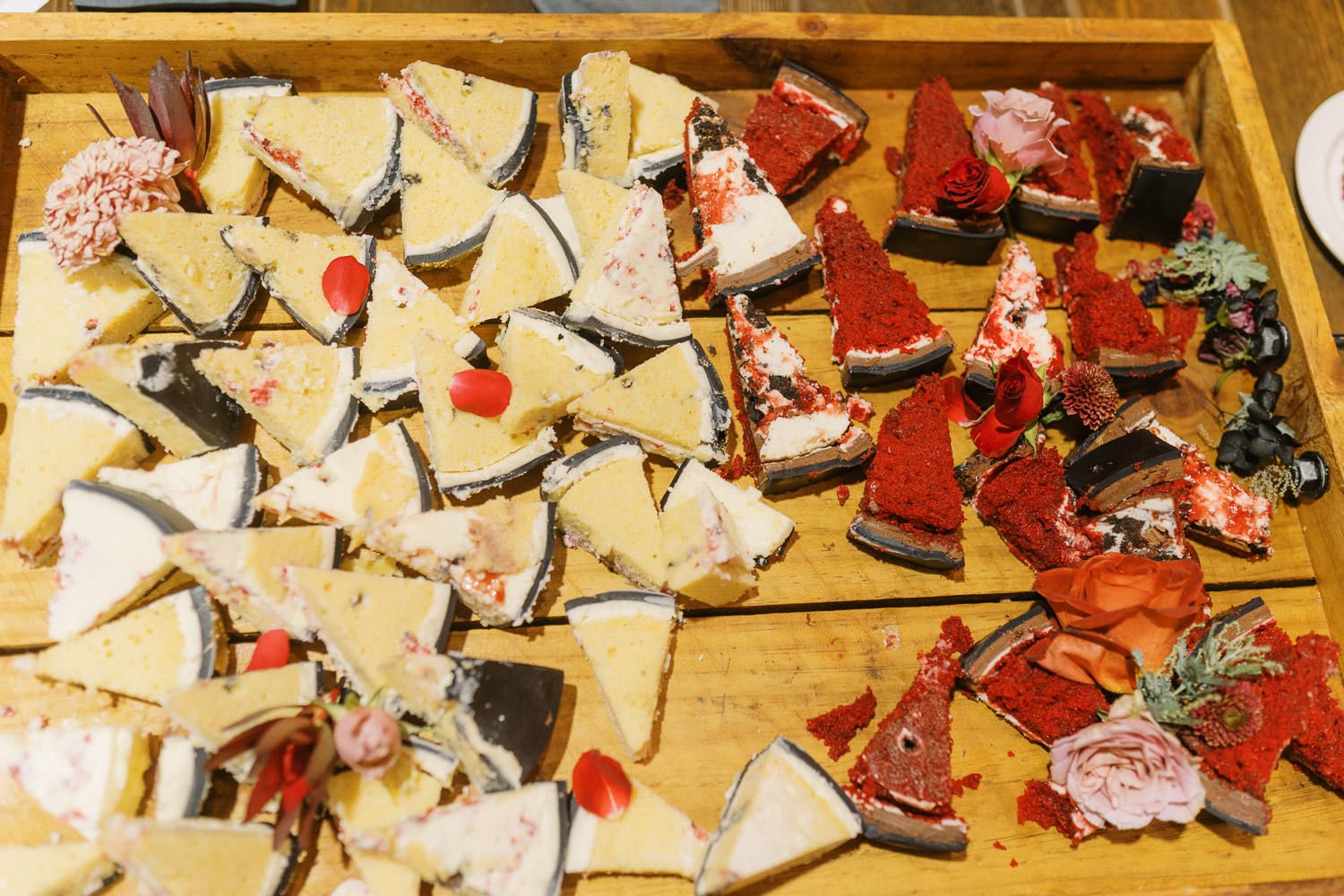 Assorted gourmet open-faced sandwiches and canapes arranged on a wooden serving tray at a catered event.