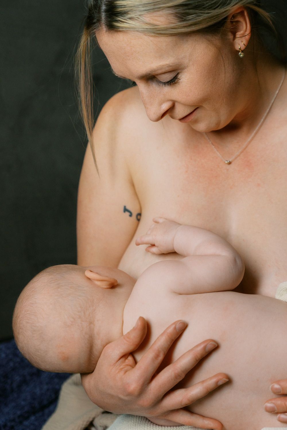 A mother tenderly breastfeeding her newborn baby, sharing a peaceful bonding moment.
