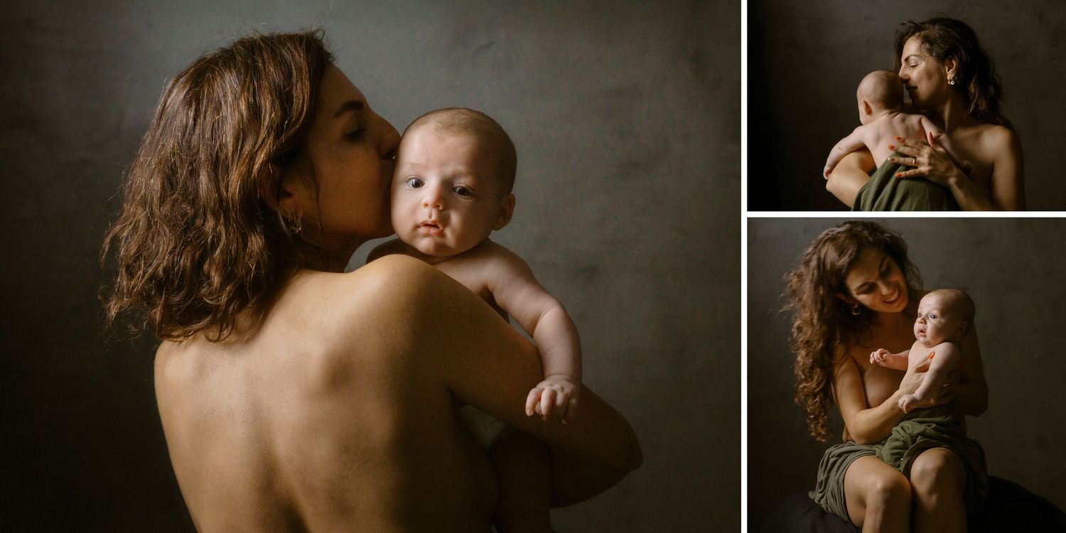A mother tenderly kisses her newborn baby in a warm studio portrait session capturing maternal love.