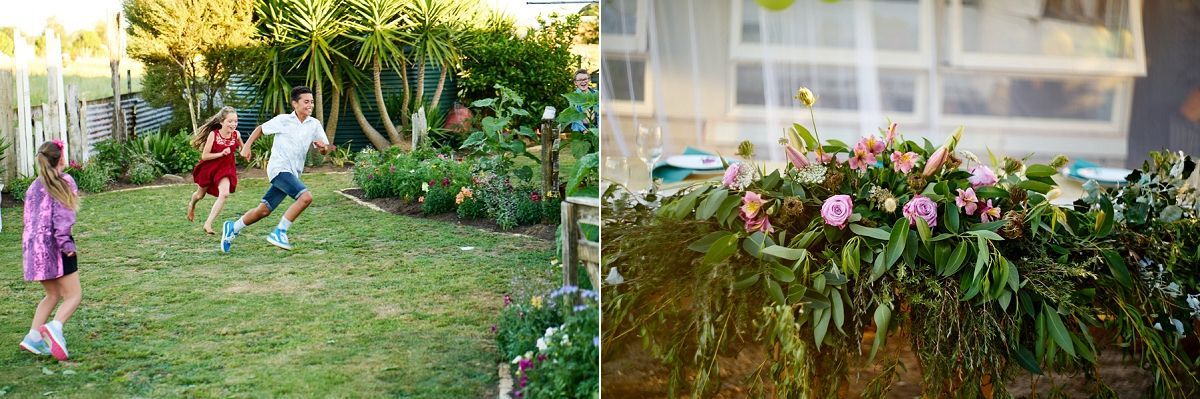 Children playing in a lush green backyard garden beside vibrant pink tropical flowers in a sunny outdoor setting.
