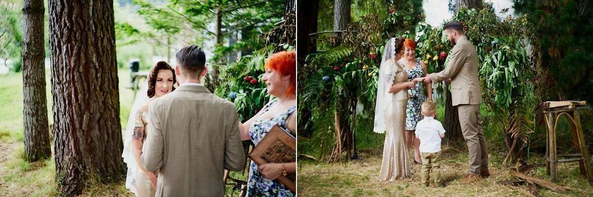 Outdoor wedding ceremony under trees with couple exchanging vows, officiant, and guests in a lush garden setting.