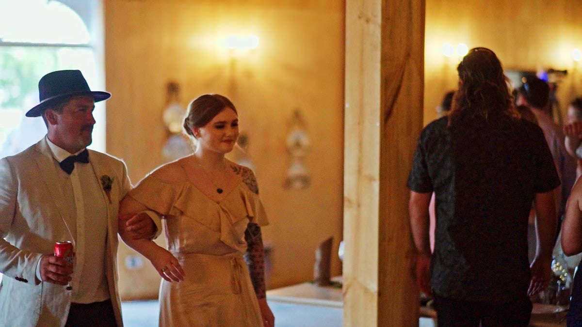 Guests in vintage attire socializing at an elegant rustic wedding reception venue.