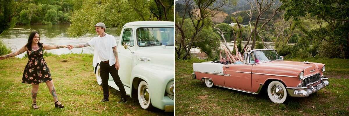 Couple posing by a vintage white truck near a river, alongside a classic pink Chevrolet convertible in a green field.