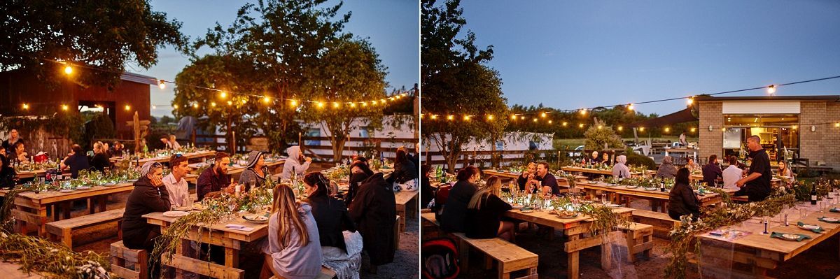 Outdoor evening wedding reception with string lights, long tables, floral centerpieces, and guests dining under a twilight sky.