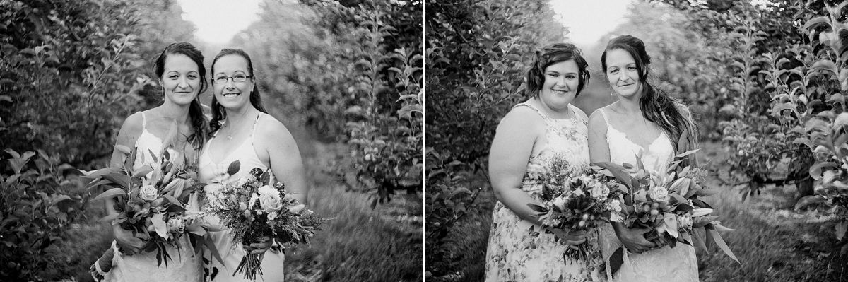 Two brides in white dresses holding floral bouquets pose together outdoors in a black and white wedding portrait.