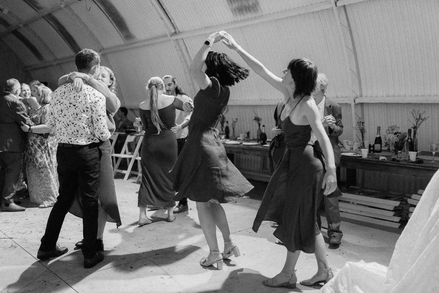 Black and white photo of couples dancing at a vintage swing dance event inside a tent venue.