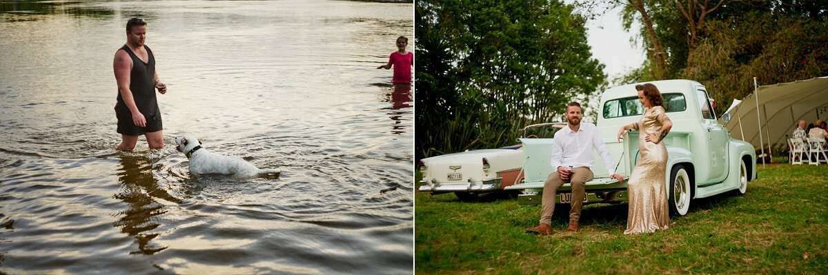 Bride and groom pose beside a vintage mint green truck outdoors, while guests wade with a dog in a nearby river.