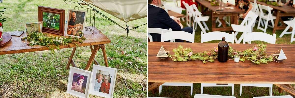 Rustic outdoor wedding decor with wooden easels displaying framed photos and greenery centerpieces on farm tables.