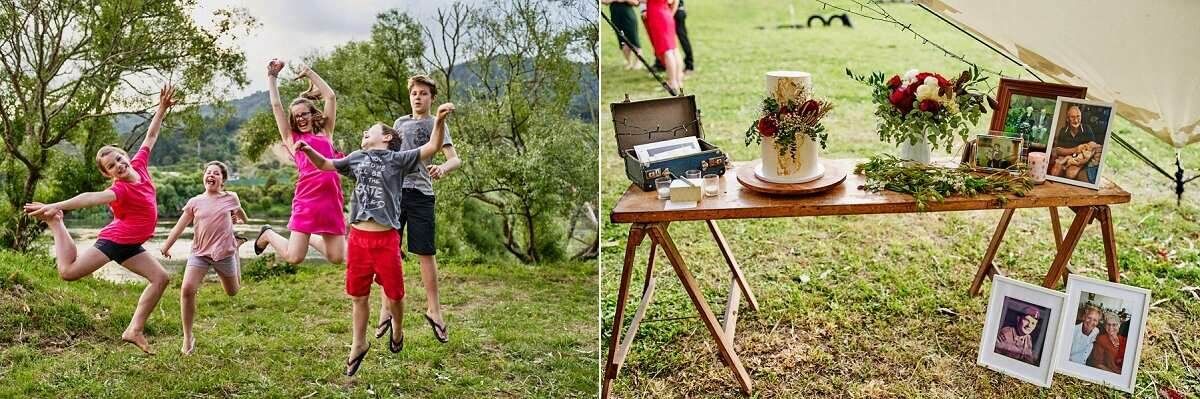 Wedding guests play lawn games outdoors while a rustic wooden table displays floral arrangements and framed photos.