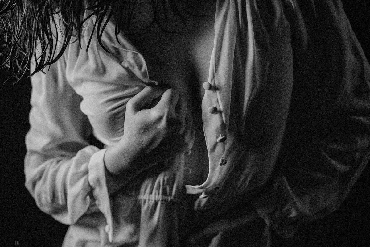 Monochrome boudoir photo of a woman in an open white button-down shirt, elegant fine art style.