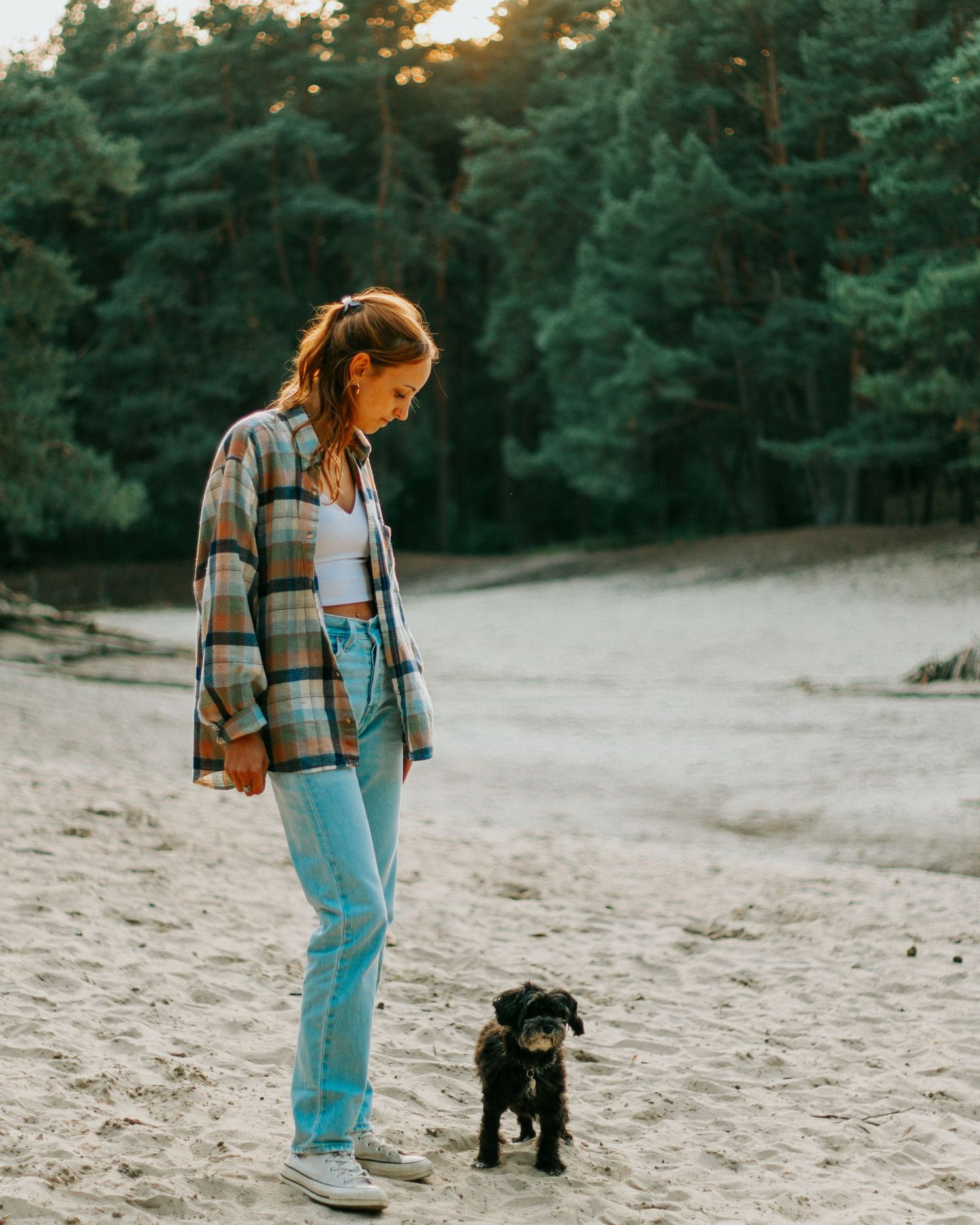 Hundeshooting - Junge Frau mit ihrem Hund im Sand.