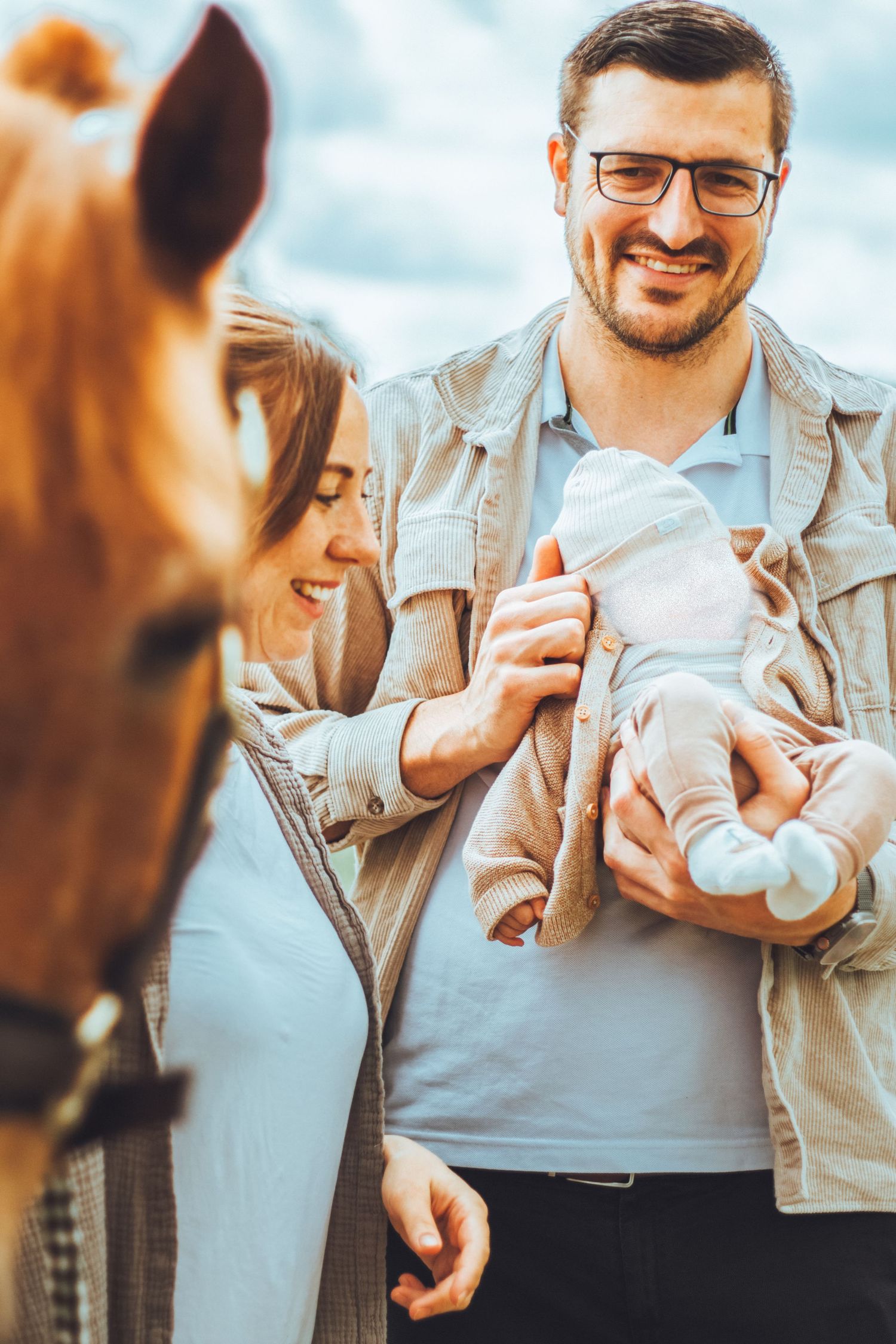 Familienshooting - Baby und Pferd. Paarshooting. Mann, Frau und Kind mit Pony.