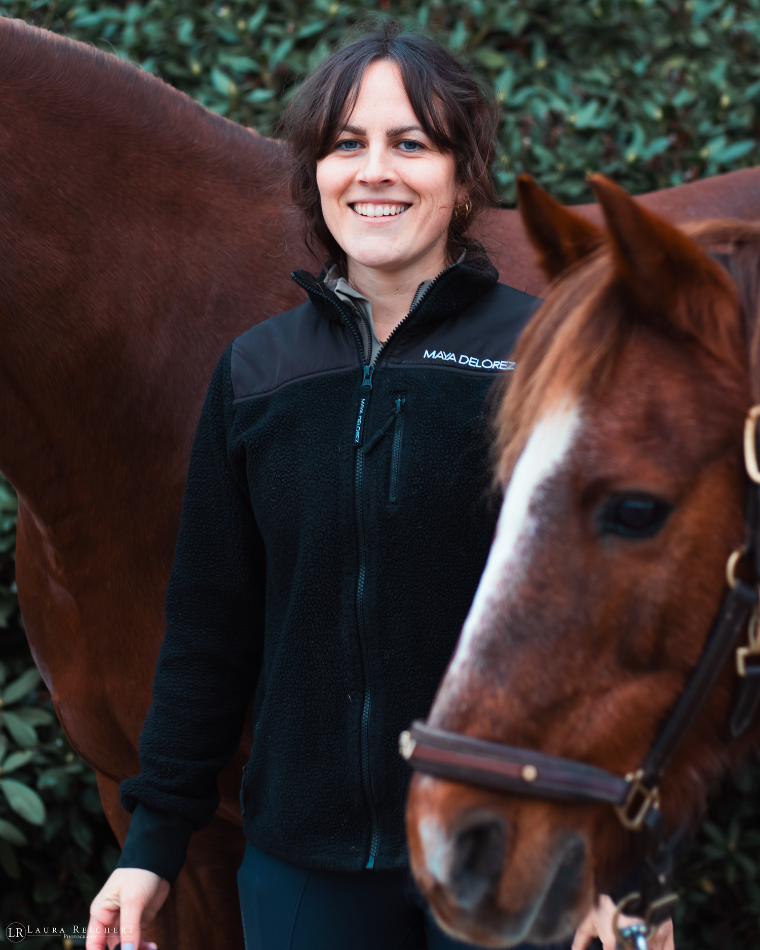 Frau mit zwei Ponys an der Hand.