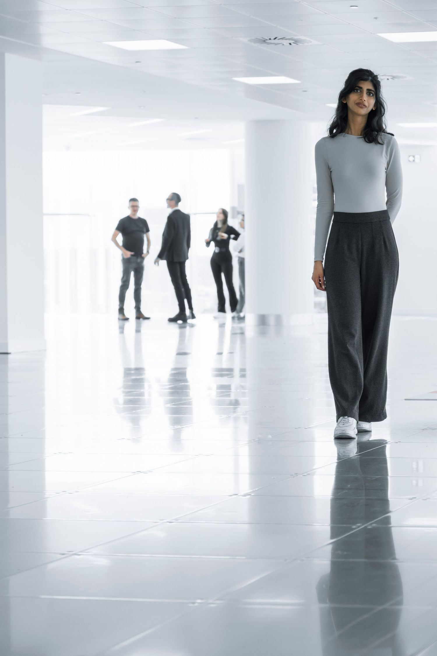 Bold editorial portrait of a model against a bright monochrome office space