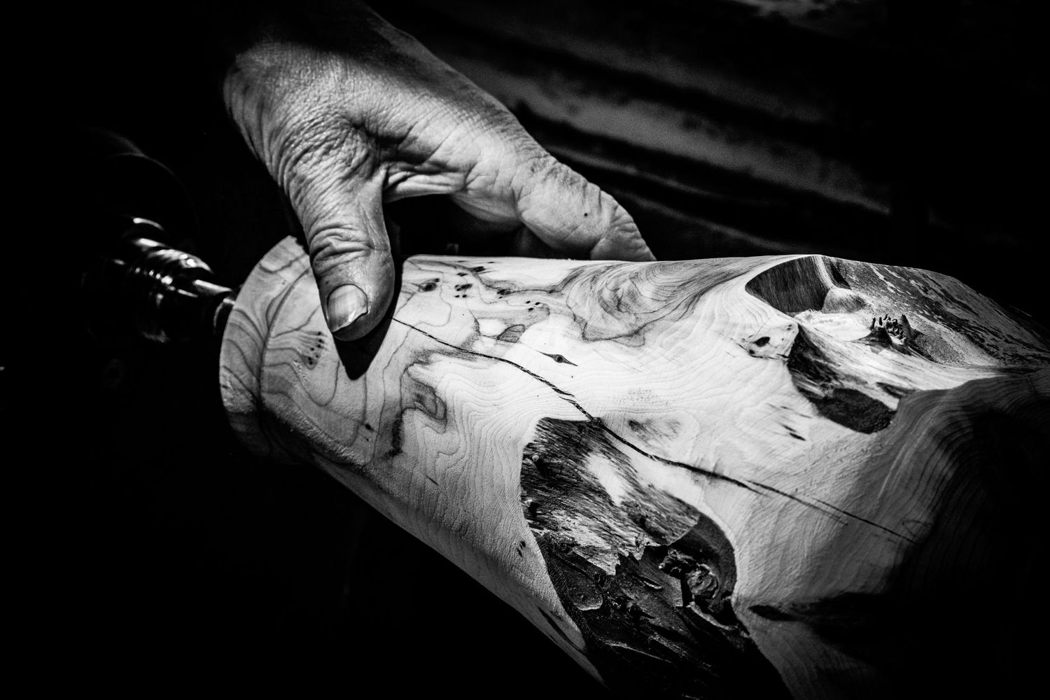 Black and white close-up of a hand resting on a turned wooded block, photographed by Simon Robertson.