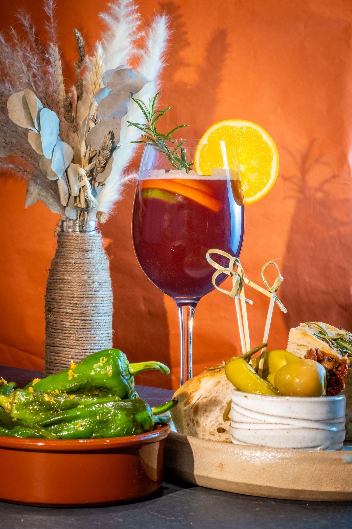 Freshly baked green peppers served with crispy potatoes and a glass of delicious red wine