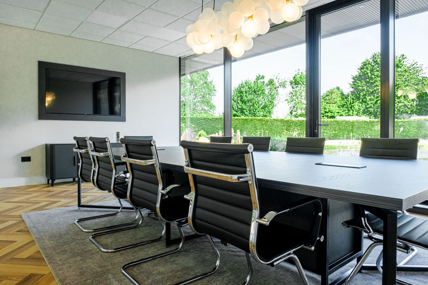 Bright modern boardroom featuring a sleek white topped table and classic Eames aluminium chairs
