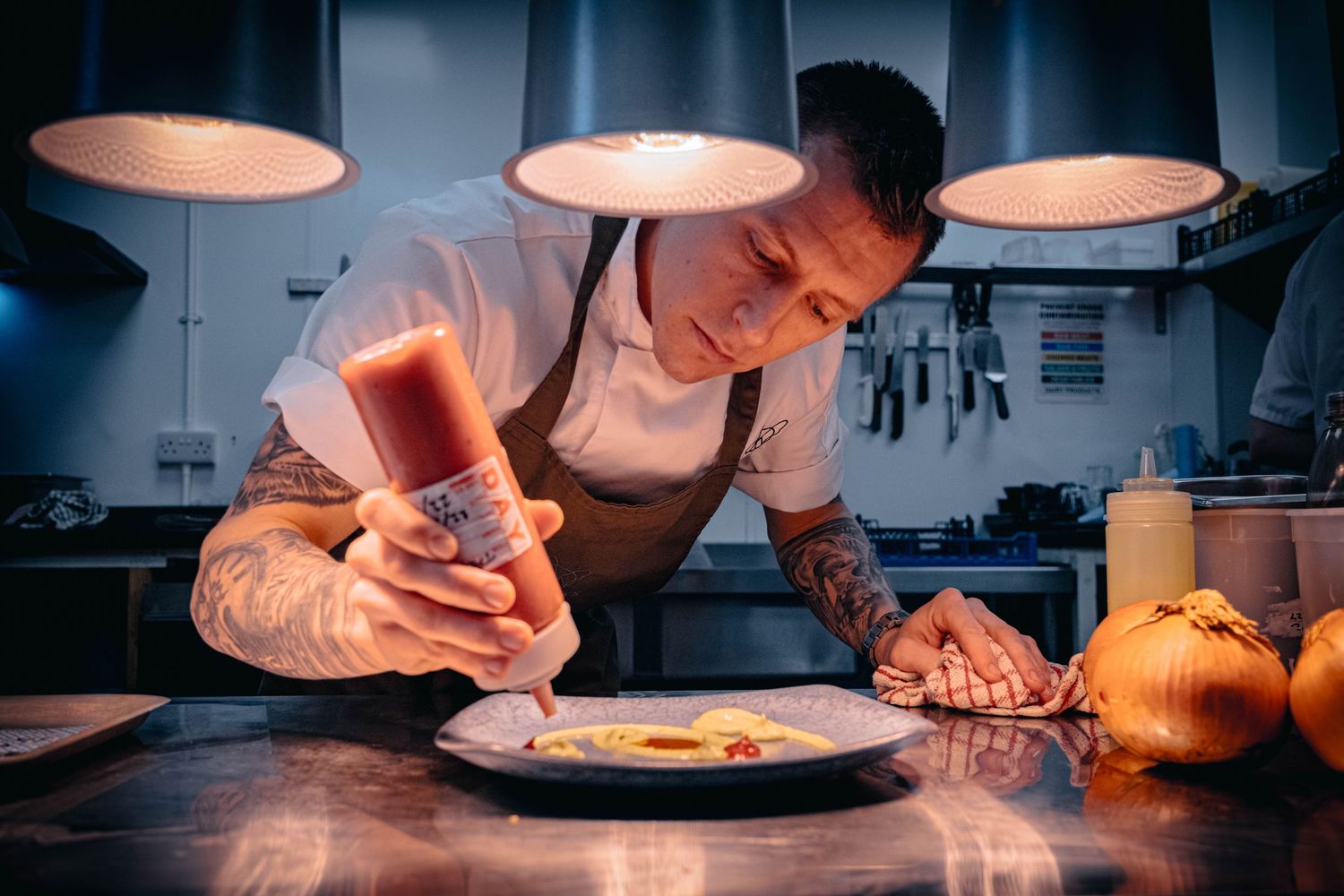 Bold editorial portrait of a chef plating up before service. Part of Shooting Chefs by Simon Robertson Photography