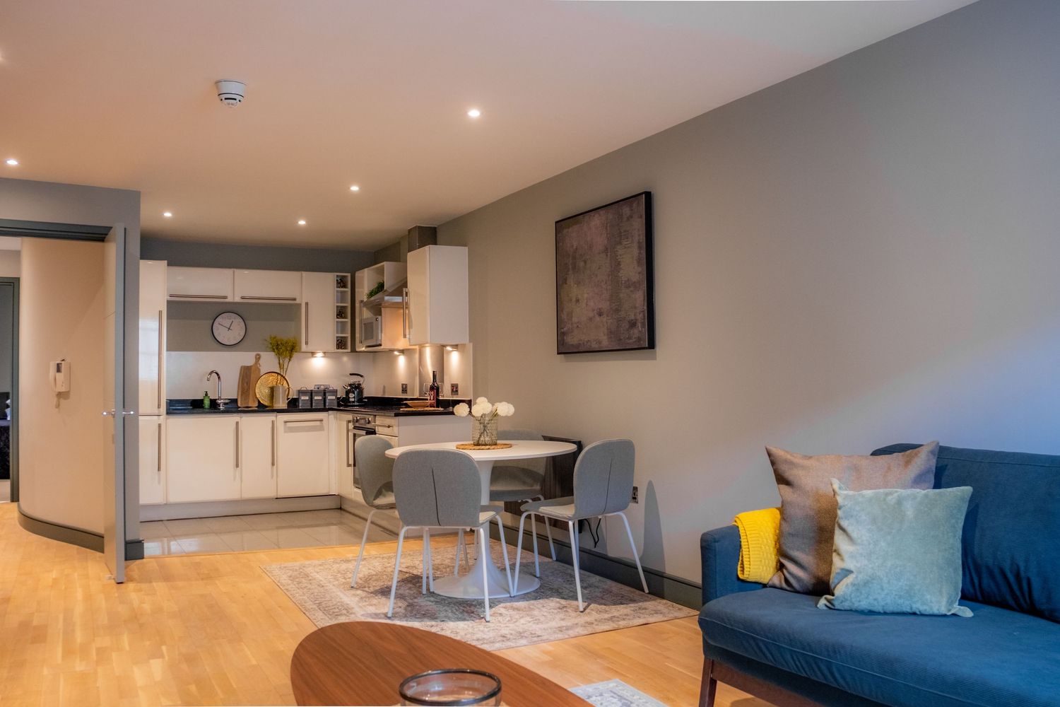 Bright modern living room and diner in an Airbnb apartment in Leeds City center featuring a blue leather sofa