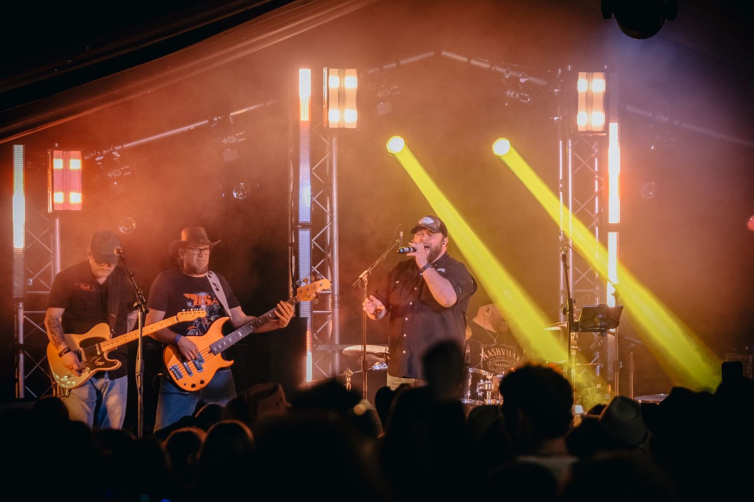 A band on stage captured during a bright light show of orange and reds at a corporate event in Yorkshire
