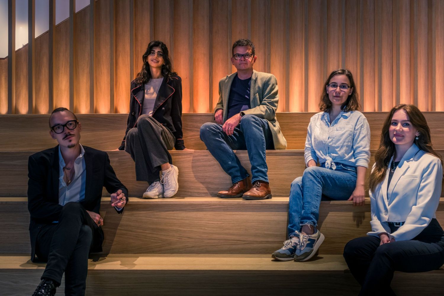 Group photograph of team of professionals gathered on a stairwell by Simon Robertson