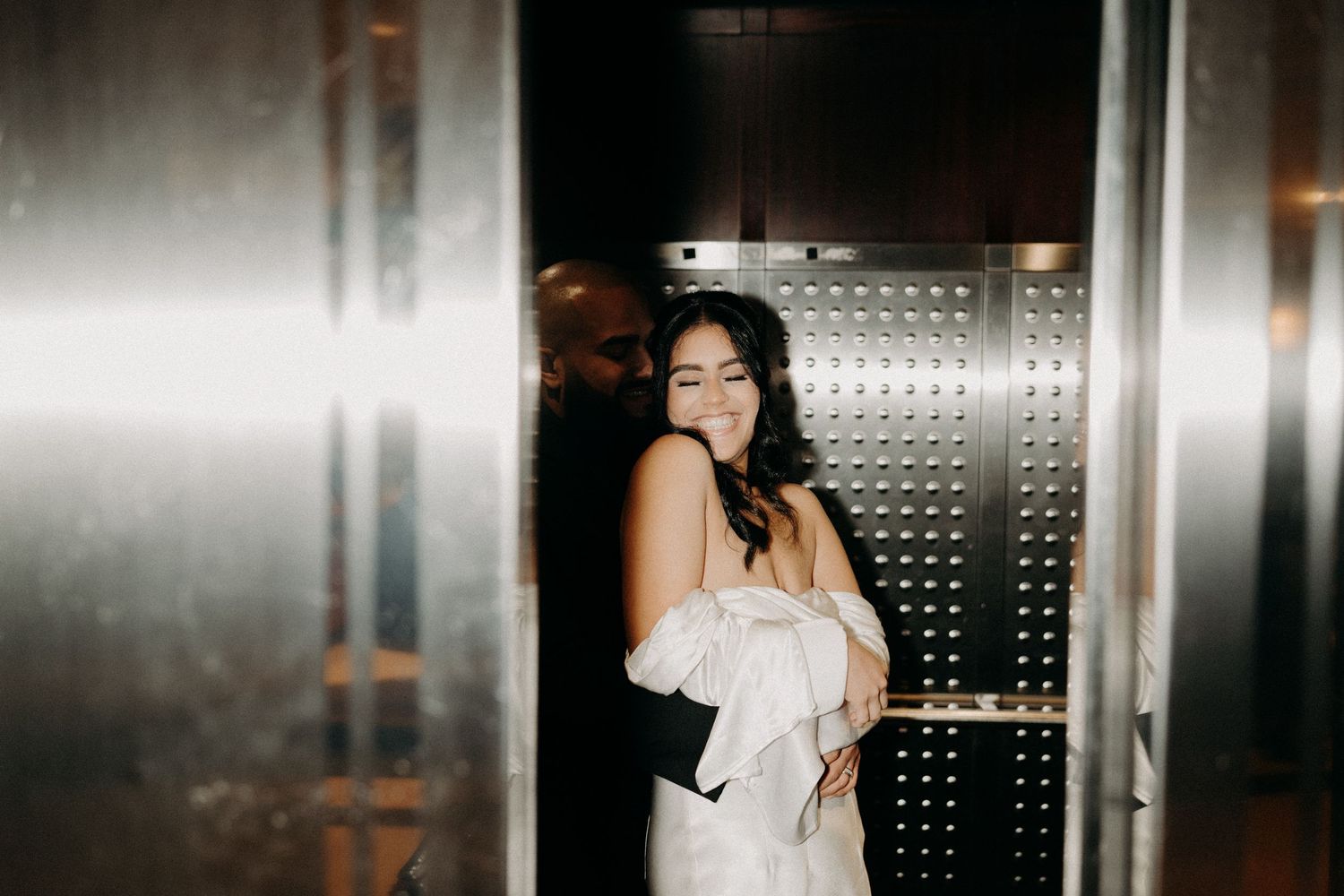 a bride at the orange county courthouse snuggling up in the elevator as hard flash flood over them