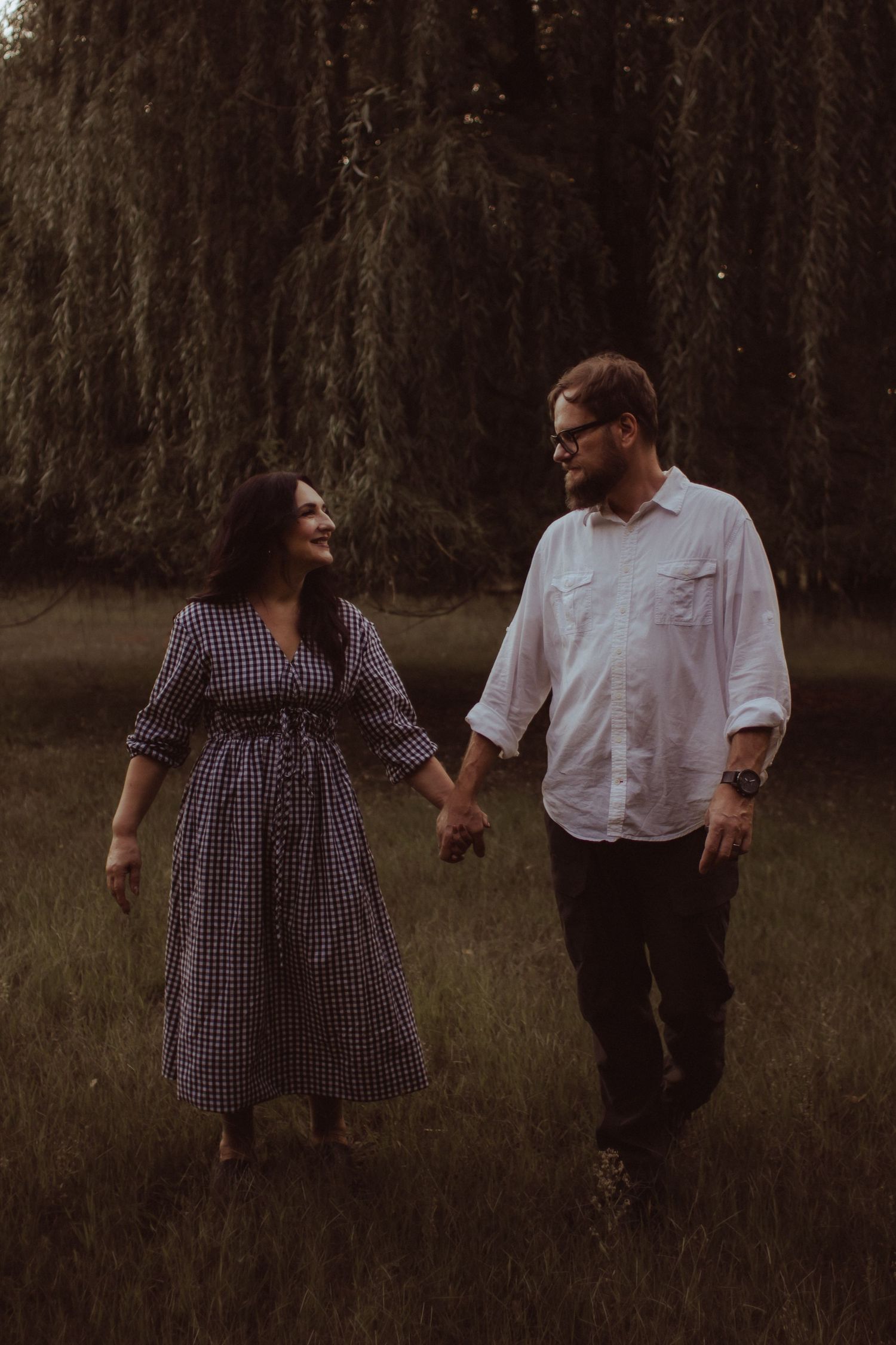 A couple walking through a grassy field in Elk River, MN Minnesota Photographer Photography Wedding Couples Engagement Session Senior Unique